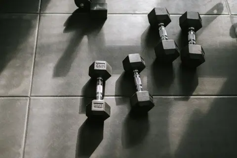 Dumbbells on a gym floor in raking light