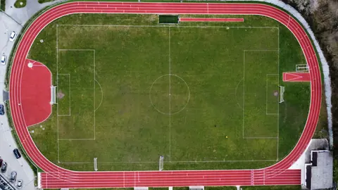 Aerial view of a 400m athletics track around a football field