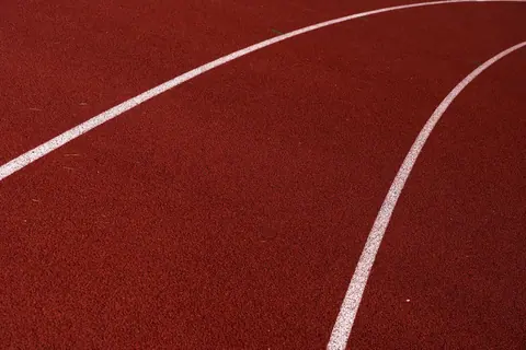Close-up of a red polyurethane running track and lane markings